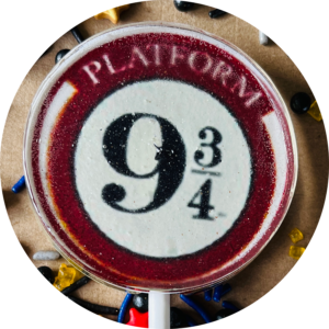 transparent lollipop with picture of the platform nine and three quarters sign in the middle